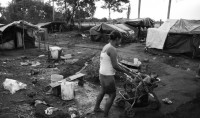 A situação nos acampamentos à beira da estrada é precária. 'Quando cheguei ao acampamento, ela estava dando banho nos bebês', conta a fotógrafa. A comunidade havia perfurado um poço, de onde tirava água potável e onde as crianças eram banhadas. Foto: Rosa Gauditano/Studio R